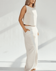 Woman wearing a stylish linen wide leg and crop top set, showcasing a comfortable fit and practical pockets.