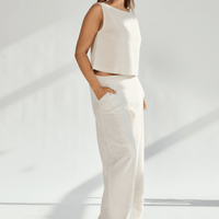 Woman wearing a stylish linen wide leg and crop top set, showcasing a comfortable fit and practical pockets.