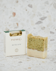 Nettle cold pressed olive oil soap bar by PATARA, with packaging and a slice displayed on a textured background.