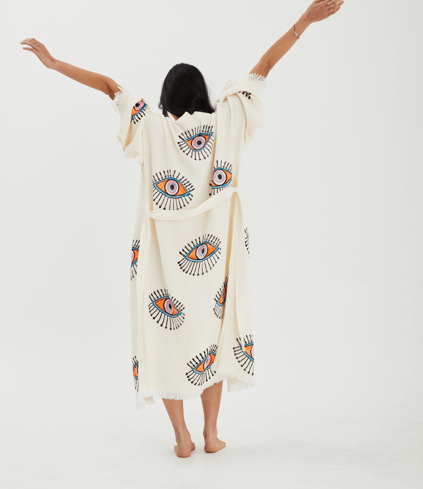Back view of a woman in an Evil Eye Robe, showcasing its handpainted design and relaxed kimono style.