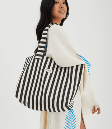 Herringbone woven linen tote bag in Black stripe worn over shoulder