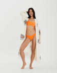 Model wearing a handcrafted Evil Eye Robe over a bikini, showcasing its elegant kimono design and colorful print.