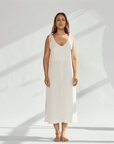 Model wearing a soft cotton dress with tied straps, showcasing a relaxed fit and elegant design.