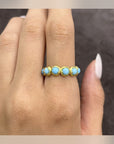 Aegean Five Stone Ring with turquoise-blue accents in gold-tone settings, worn on a hand