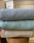 Stack of three patterned fabric rolls on a wooden surface