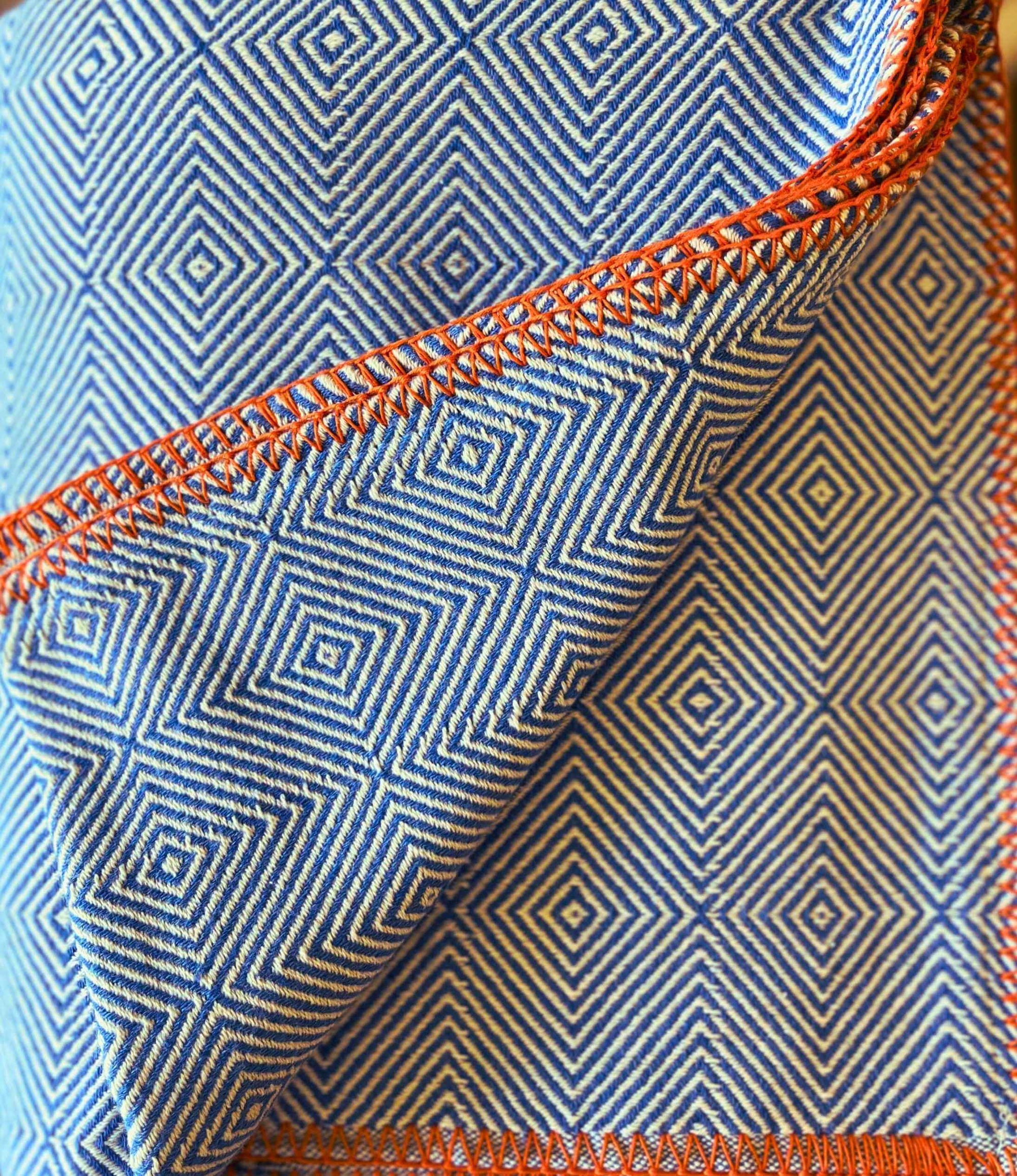 Close-up of blue fabric with orange stitching