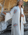Model wearing a handcrafted Evil Eye Robe made from soft Buldan muslin cotton by the beach.