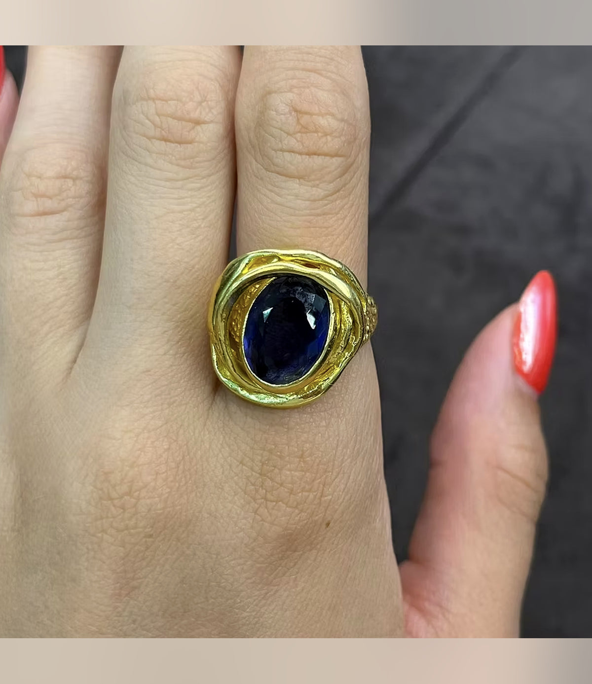 Saphira Amethyst Statement Ring with an oval faceted centrepiece and sculptural gold-tone setting, worn on a hand
