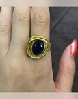 Saphira Amethyst Statement Ring with an oval faceted centrepiece and sculptural gold-tone setting, worn on a hand