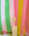 Striped fabric with green, pink, and yellow colors and a brand tag.