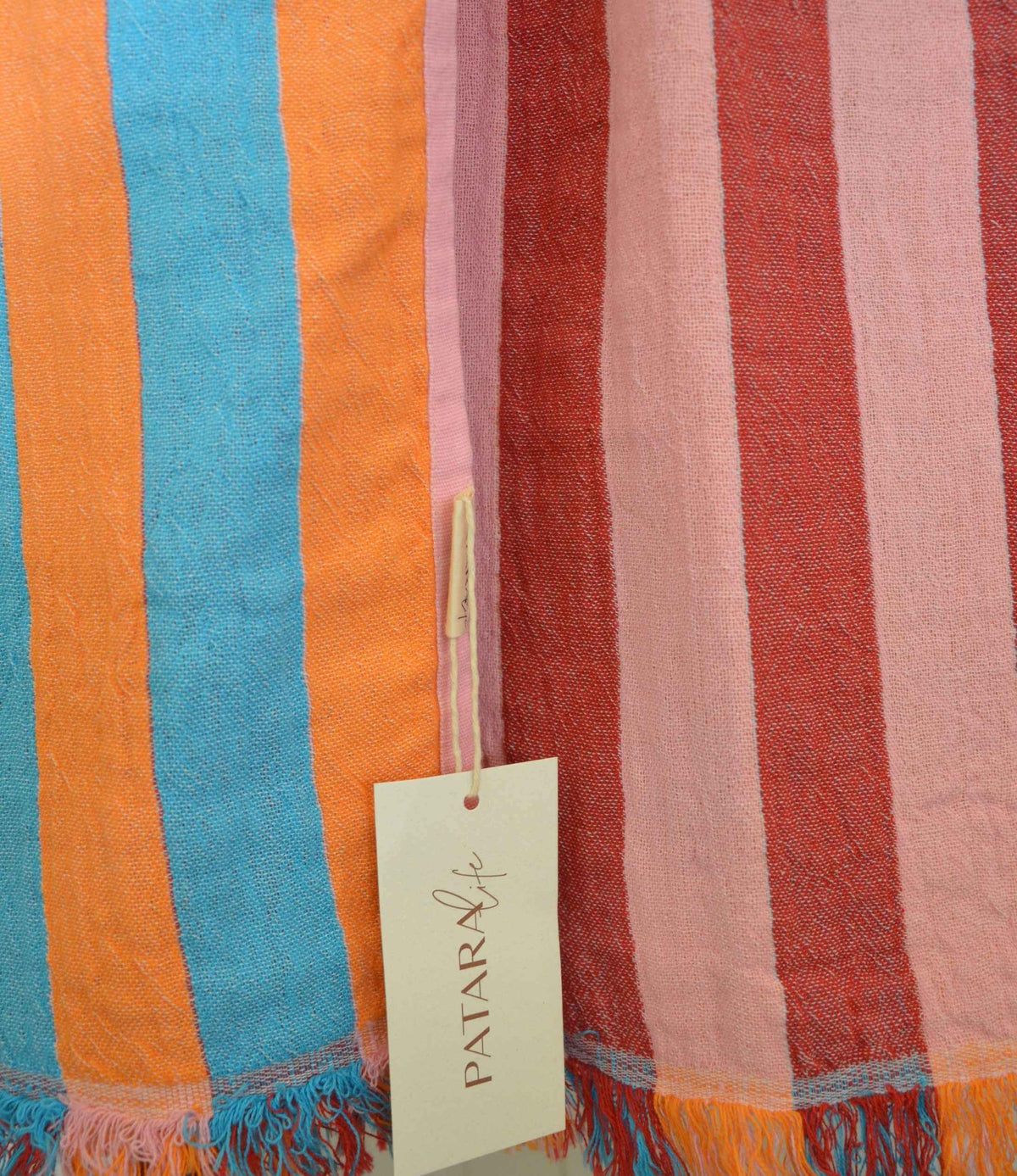 Striped fabric with colorful stripes and a visible brand tag.