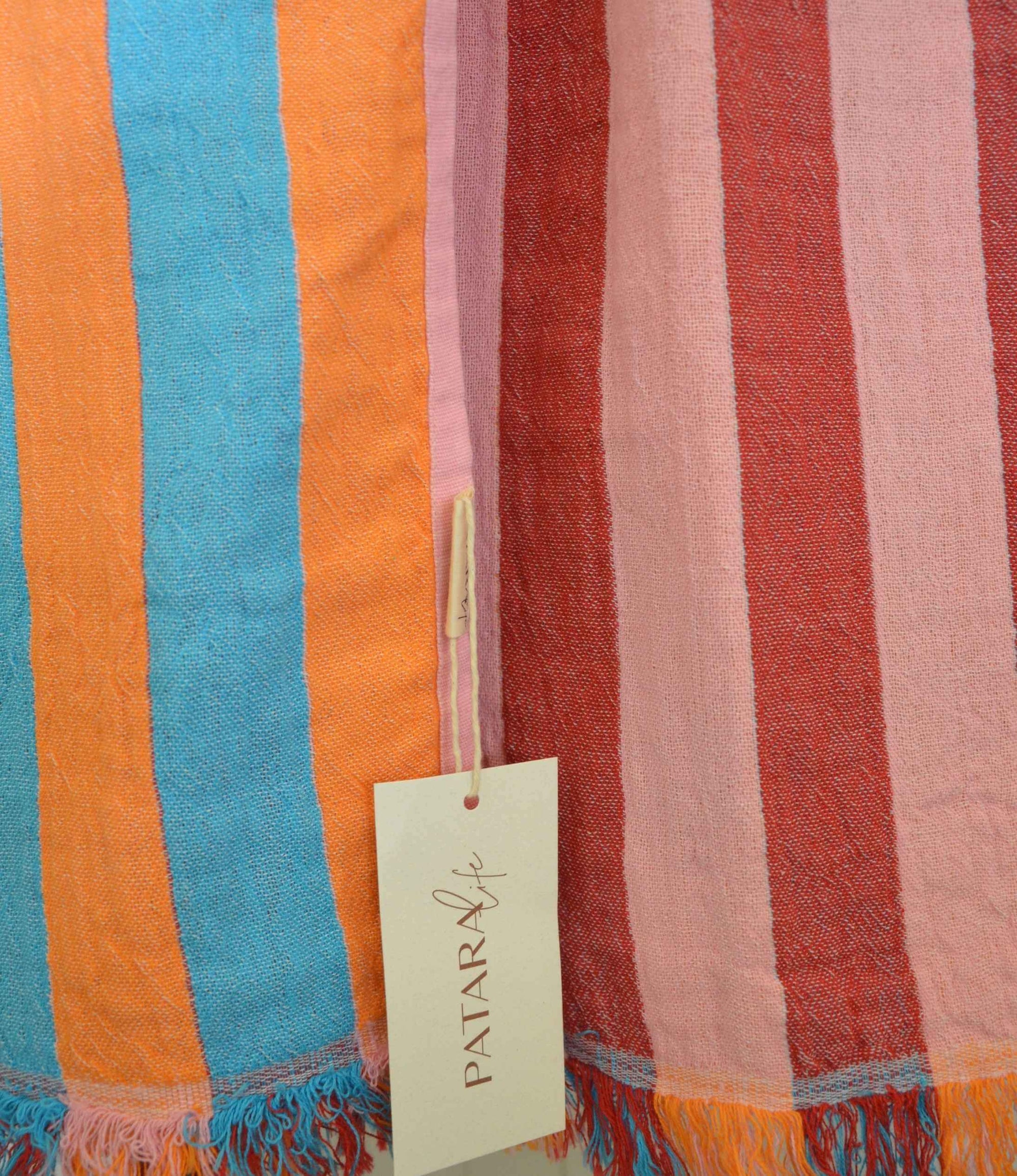 Striped fabric with colorful stripes and a visible brand tag.