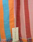 Striped fabric with colorful stripes and a visible brand tag.
