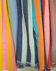 Colorful striped fabric with fringes in various colors on a white background