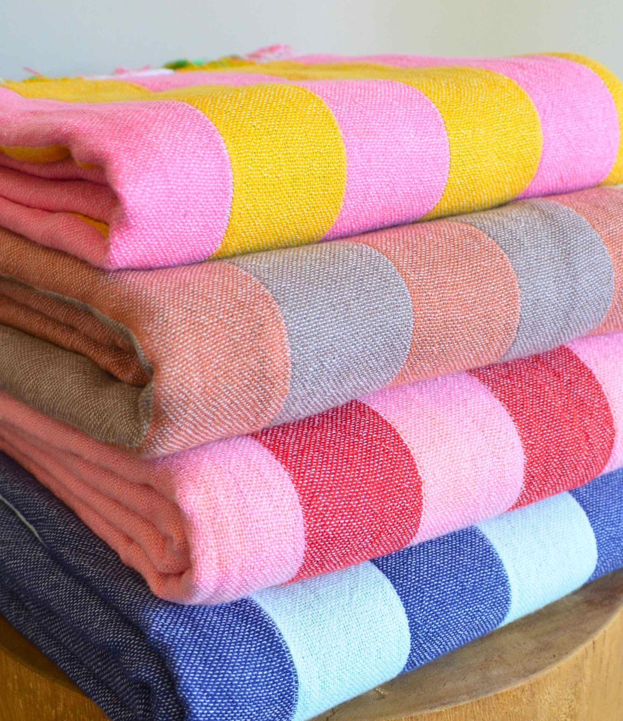 Stack of colorful patterned cloths on a wooden surface