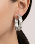 Enhanced worn shot of the Sculpted Silver Hoops