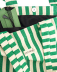 close up of pocket and snap detail of green and white beach bag