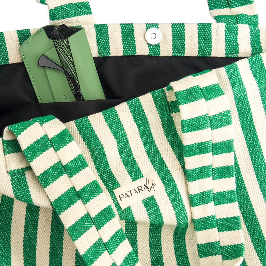 close up of pocket and snap detail of green and white beach bag