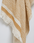 A dotted Turkish cotton "Kalkan" beach towel in mustard yellow