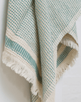 A dotted Turkish cotton "Kalkan" beach towel in sage green