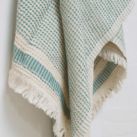 A dotted Turkish cotton "Kalkan" beach towel in sage green