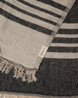 Close up of a black and beige linen & cotton premium throw layed flat